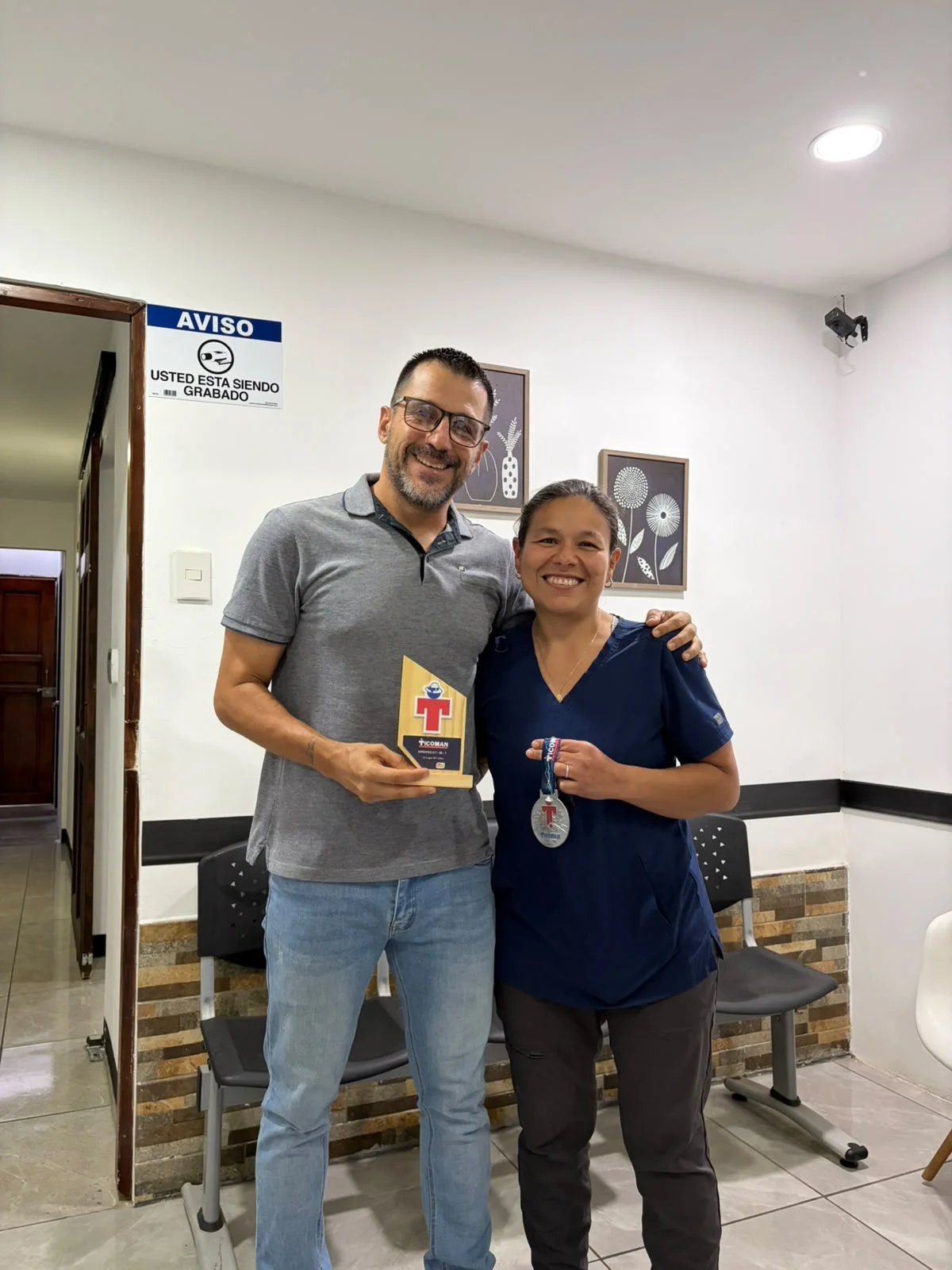 Dra. Lolita Azofeifa celebrando con el atleta de resistencia Henry Cambronero y su trofeo